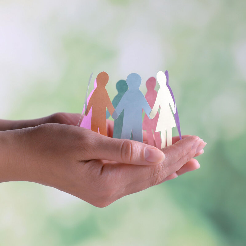 Close-up of hands holding human paper figures against a blurred background. This image illustrates the concept of diversity and inclusion. In weba Werkzeugbau's business ethics, this image symbolizes the policy of respecting human rights and complying with labor laws.