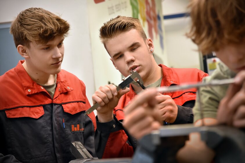 Two apprentices in the field of metal engineering, Module H6 Toolmaking Technology, are measuring a workpiece. The apprenticeship position at weba Werkzeugbau in Steyr combines practical skills with theoretical knowledge.